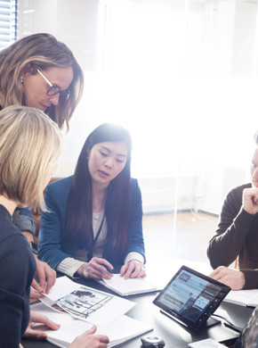 Kontormiljø med ansatte rundt et bord