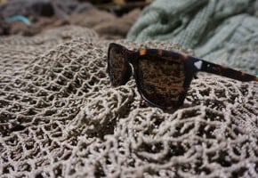 Fisketau i fokus med hav og fjell uklart i bakgrunnen.