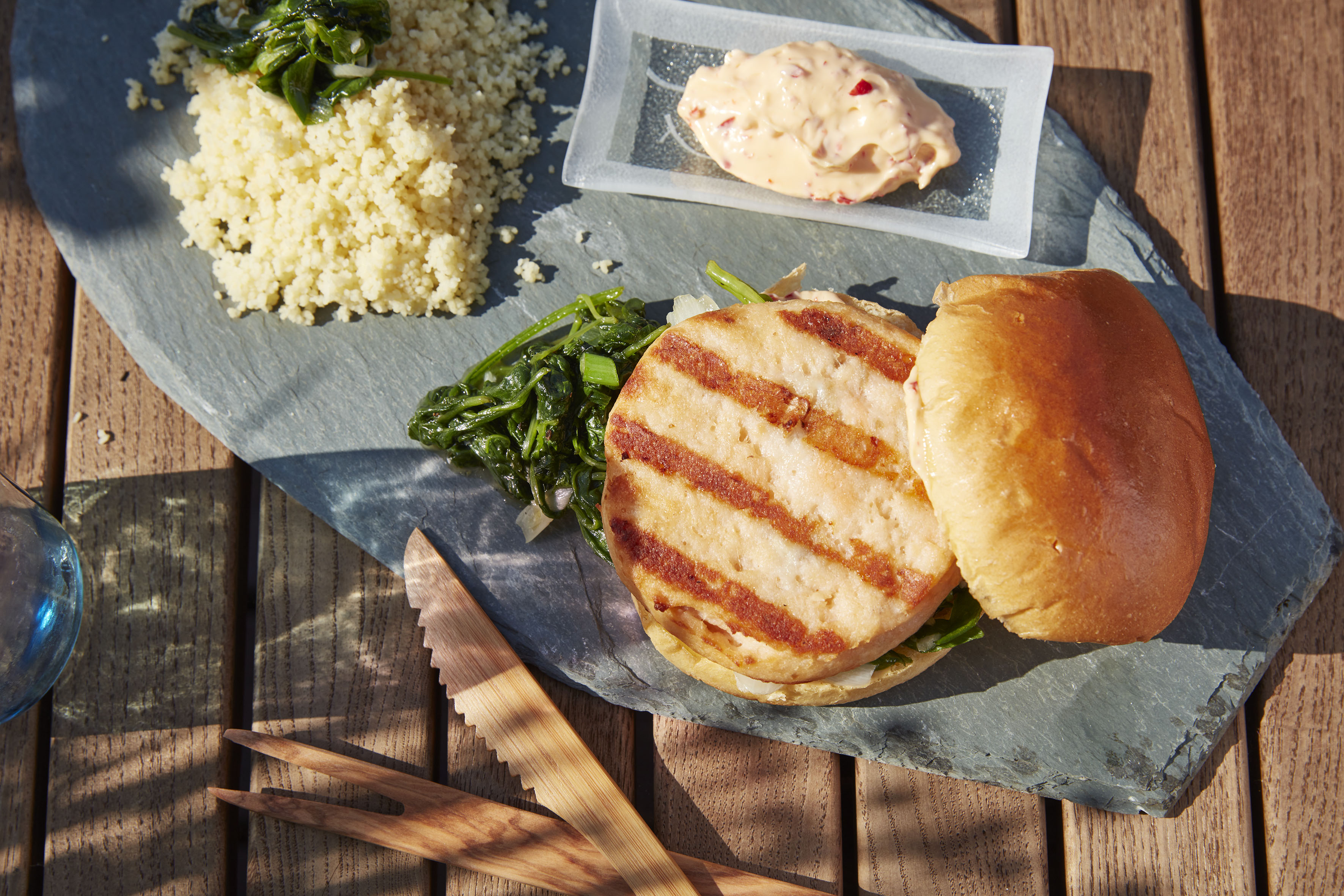 Fried salmon with salad and sesame seeds on a plate placed on a  nicely set table